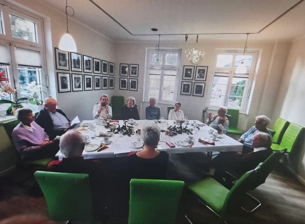 Klienten beim gemeinsamen Kaffeetrinken an einer festlich gedeckten Tafel