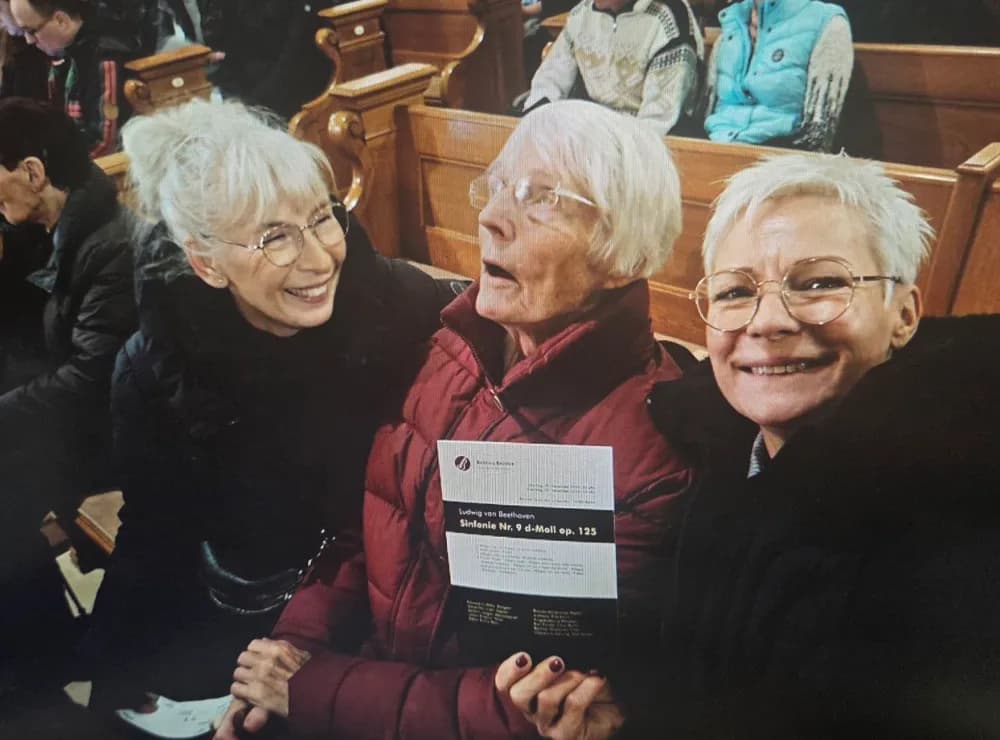 Klientin mit zwei Mitarbeiterinnen in einer Kirche bei einem Konzert