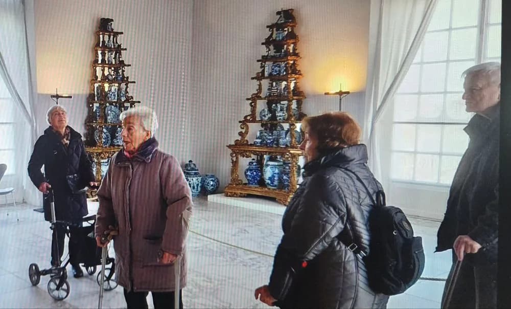 Klienten bei einem Museumsbesuch vor Regalen mit blau-weißem Porzellan