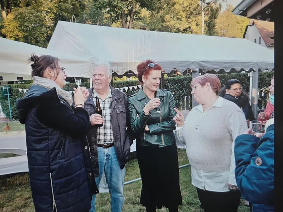 Gäste im Gespräch im Garten vor dem Zelt