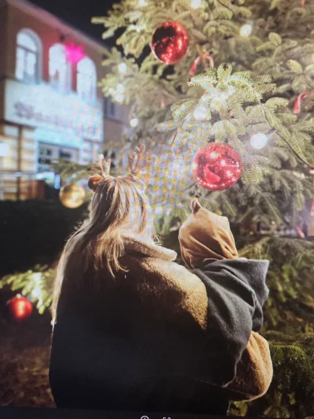Blick auf die Kugeln und Lichter des Weihnachtsbaums am Abend